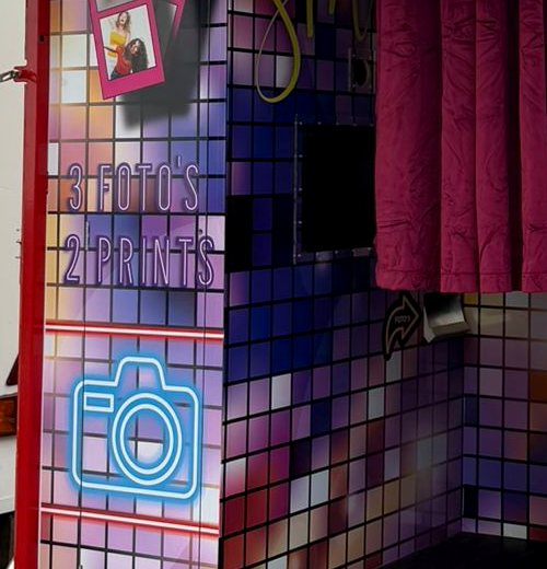 Neon cameralogo met de tekst 3 foto's, 2 prints op de wand van de booth